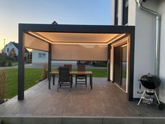 an outdoor dining area with patio furniture and bbq grill in the back yard at dusk