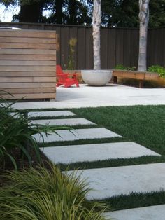 a modern backyard with grass and stepping stones