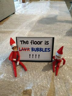 two elfs sitting on top of a bed next to a sign that says the floor is lava bubbles