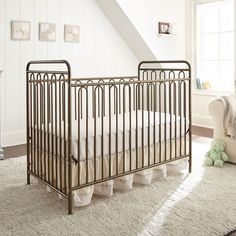 a baby crib in the corner of a room with white walls and carpeted floor