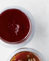 two bowls filled with soup sitting on top of a white table next to each other