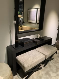 a black table with a bench and mirror in the corner next to it on top of a carpeted floor