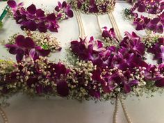 purple orchids and baby's breath flowers are laid out on a white table