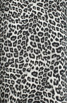 an animal print fabric with black and white spots on the top, as well as dark grey