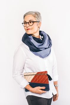 For the on-the-go fashionista. Complete your simple travel look with handmade, Anchal accessories. Here, our oversized, striped Blue infinity scarf is styled with the Autumn Colorblock clutch. Both are made with organic cotton and hand-stitched with lined, paneled detailing. #anchalproject #fairtrade #designingchange #artisanmade #ethicaldesign #sustainableliving #sustainabletravel #travelaccessories #ecofriendlyaccessories Luxury Resort Wear, Color Block Scarf, Embroidery Materials, Small Pouch, Embroidered Details, Sustainable Gifts, Small Pouches, White Embroidery, Stay Organized