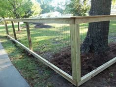 a wooden fence is next to a tree