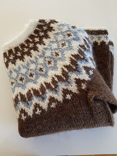 a brown and white knitted hat sitting on top of a wooden table