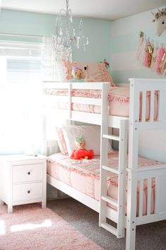 a white bunk bed sitting next to a window