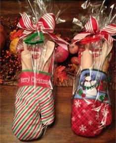 two christmas stockings wrapped in cellophane and sitting on a table with candy canes