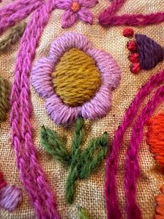 an assortment of colorful yarns and flowers on a piece of cloth