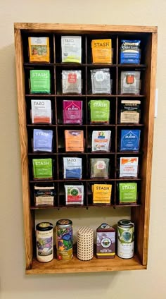 a wooden spice rack filled with lots of different types of spices on top of a wall