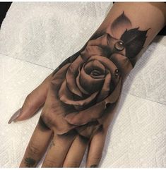 a woman's hand with a rose tattoo on it