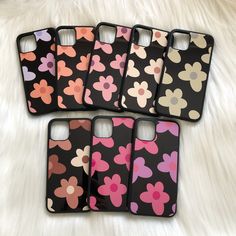 four iphone cases with flowers on them sitting on a white furnishing area next to each other