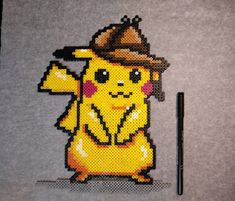 a cross stitch pikachu with a hat on it's head and a pen next to it