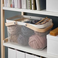 an organized storage bin on a book shelf with books and other items in the background