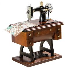 an old fashioned sewing machine sitting on top of a wooden table