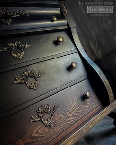 an ornate black dresser with gold accents