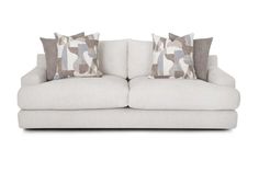 a white couch with two pillows on it's back and one pillow in the middle