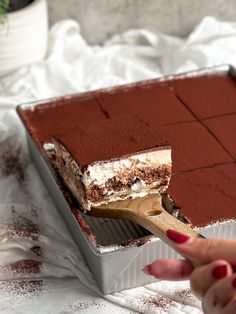 a person cutting into a cake with a wooden spoon