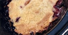 a close up of a pie in a pan on a stove top with blueberries