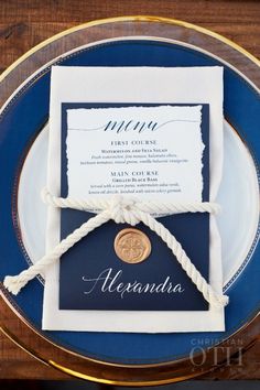 a blue and white plate topped with a place card on top of a wooden table