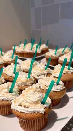 cupcakes with white frosting and green sticks on them