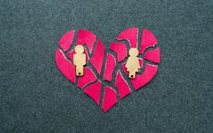 two pieces of paper cut into the shape of a heart with people on it, sitting in front of each other