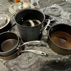 pots and pans are sitting on a table with utensils in them, ready to be cooked