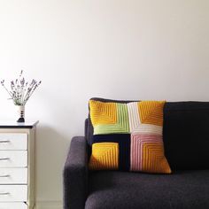 a living room with a black couch and white dresser