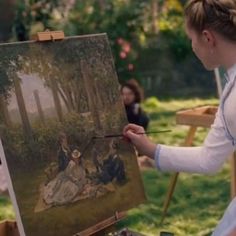 a woman is painting in an outdoor setting