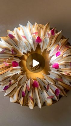 a circular light fixture made out of paper with pink flowers on the inside and bottom