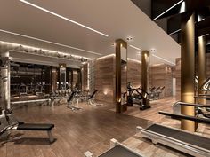 a gym with treadmills, exercise machines and other equipment in the area that is well lit