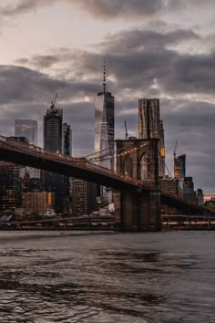 the skyline of new york city is shown from across the water at dusk, with skyscrapers in the background