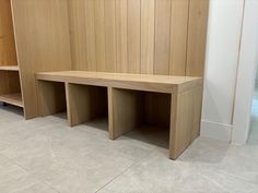 two wooden benches sitting next to each other on top of a tile floor in front of a wall