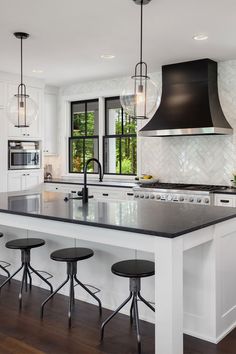 a kitchen island with four stools in front of it and an oven on the other side