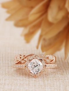 a close up of a ring with a flower in the background