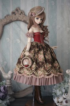 a doll dressed in a dress and hat with a purse on top of a table