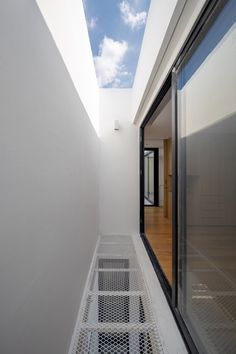 an empty hallway with sky in the background and metal grates on the floor below