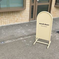 a sign on the sidewalk in front of a building that says modd shart