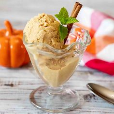 an ice cream sundae in a glass dish with cinnamon stick sticking out of it