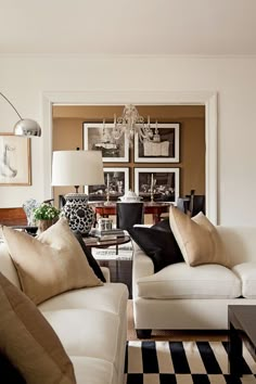 a living room filled with furniture and a chandelier hanging from the ceiling over a black and white checkered floor