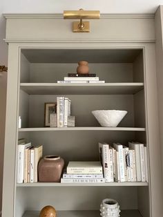 a book shelf with books and vases on it