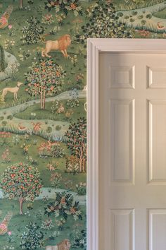 an open door in front of a wallpapered room with animals and trees on it