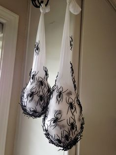 two bras hanging from the side of a window with spider webs on them