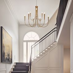 an elegant staircase with chandelier and painting on the wall