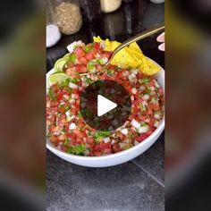 a white bowl filled with salsa next to tortilla chips and guacamole