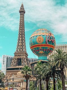 the eiffel tower in paris, france with palm trees and buildings behind it