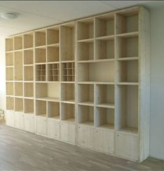 an empty room with wooden shelves and hard wood flooring