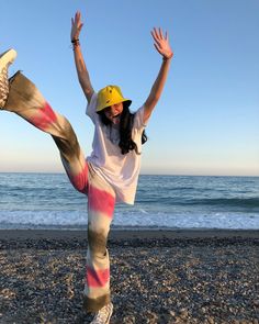 a woman is doing yoga on the beach