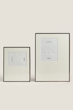 two white framed photographs sitting next to each other